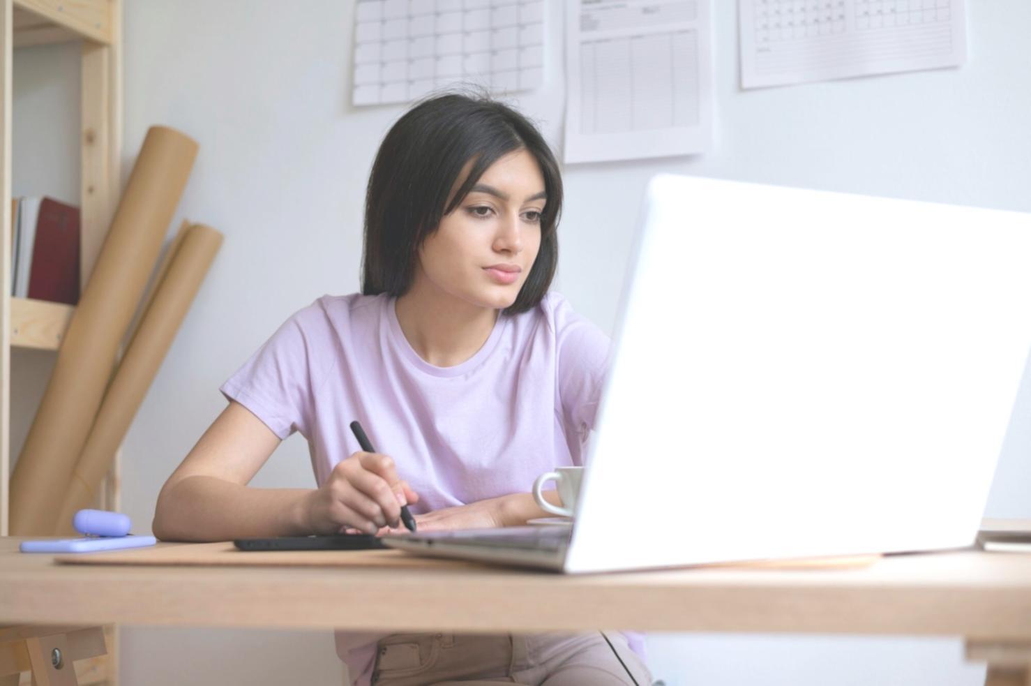 Person taking notes during an online journalism course